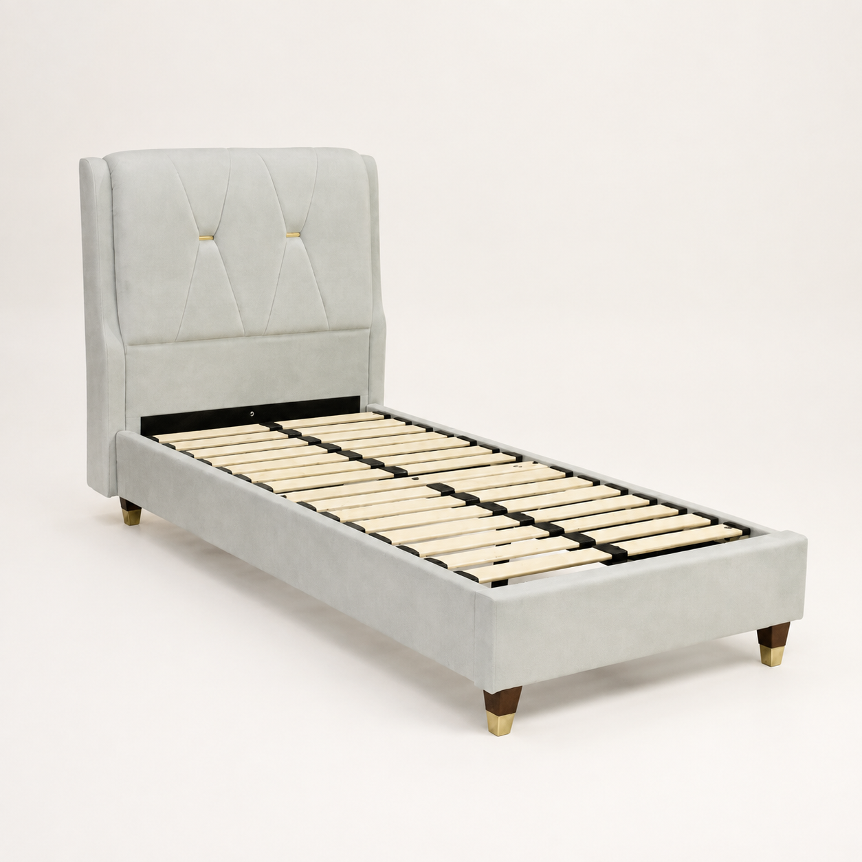 A light gray upholstered bed frame with a tall tufted headboard, slatted wooden base, and small gold-toned legs, photographed on a clean white studio background.