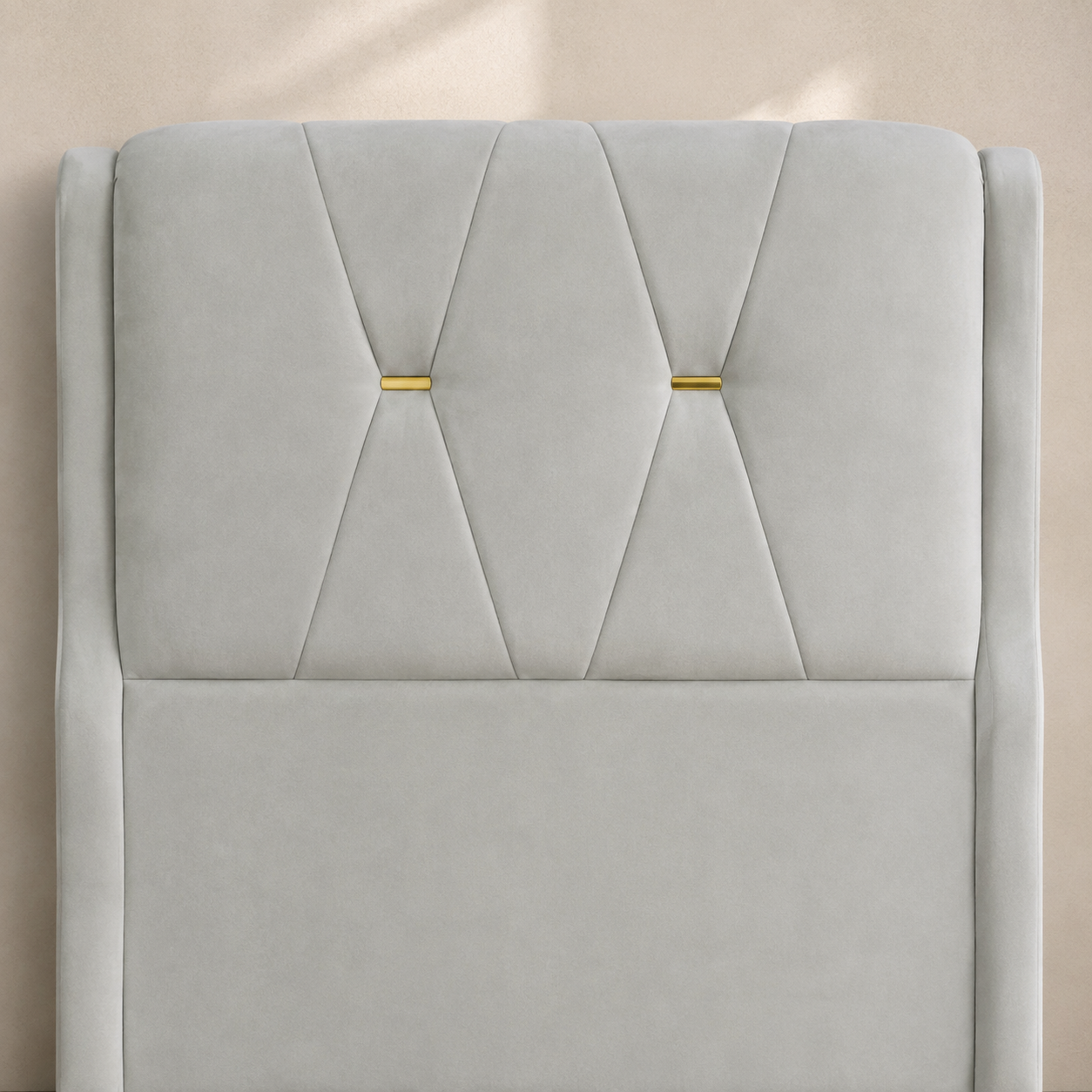 Close view of the RANIYA suede headboard with two hourglass seams and gold accents