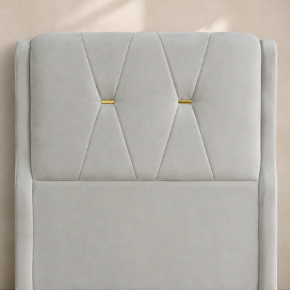 Close view of the RANIYA suede headboard with two hourglass seams and gold accents