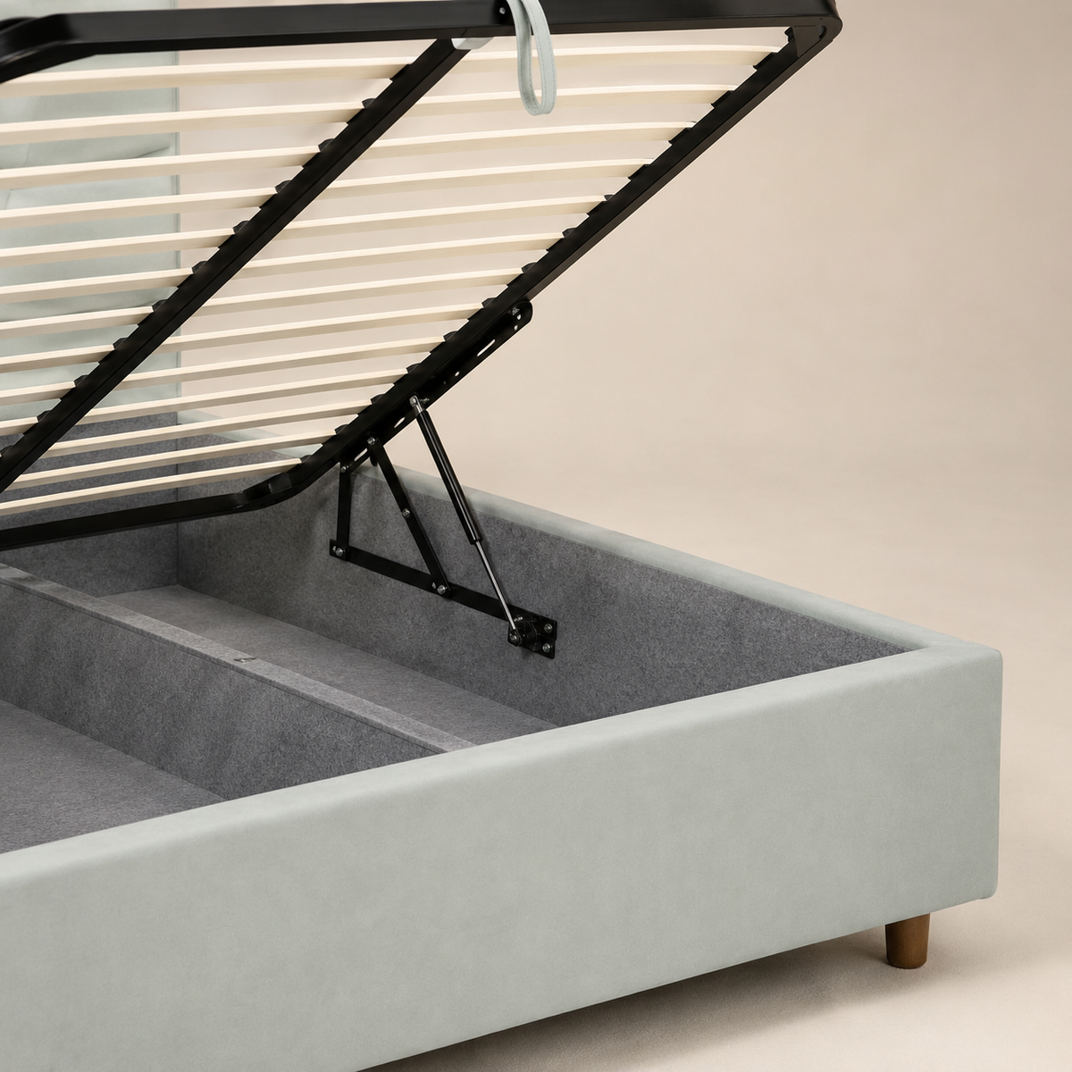 SAKYNA storage bed close-up showing its gas strut, metal frame, wooden slats and lined compartment